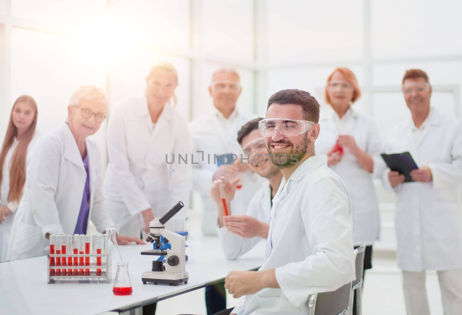 close up. smiling scientist sitting at a laboratory table .