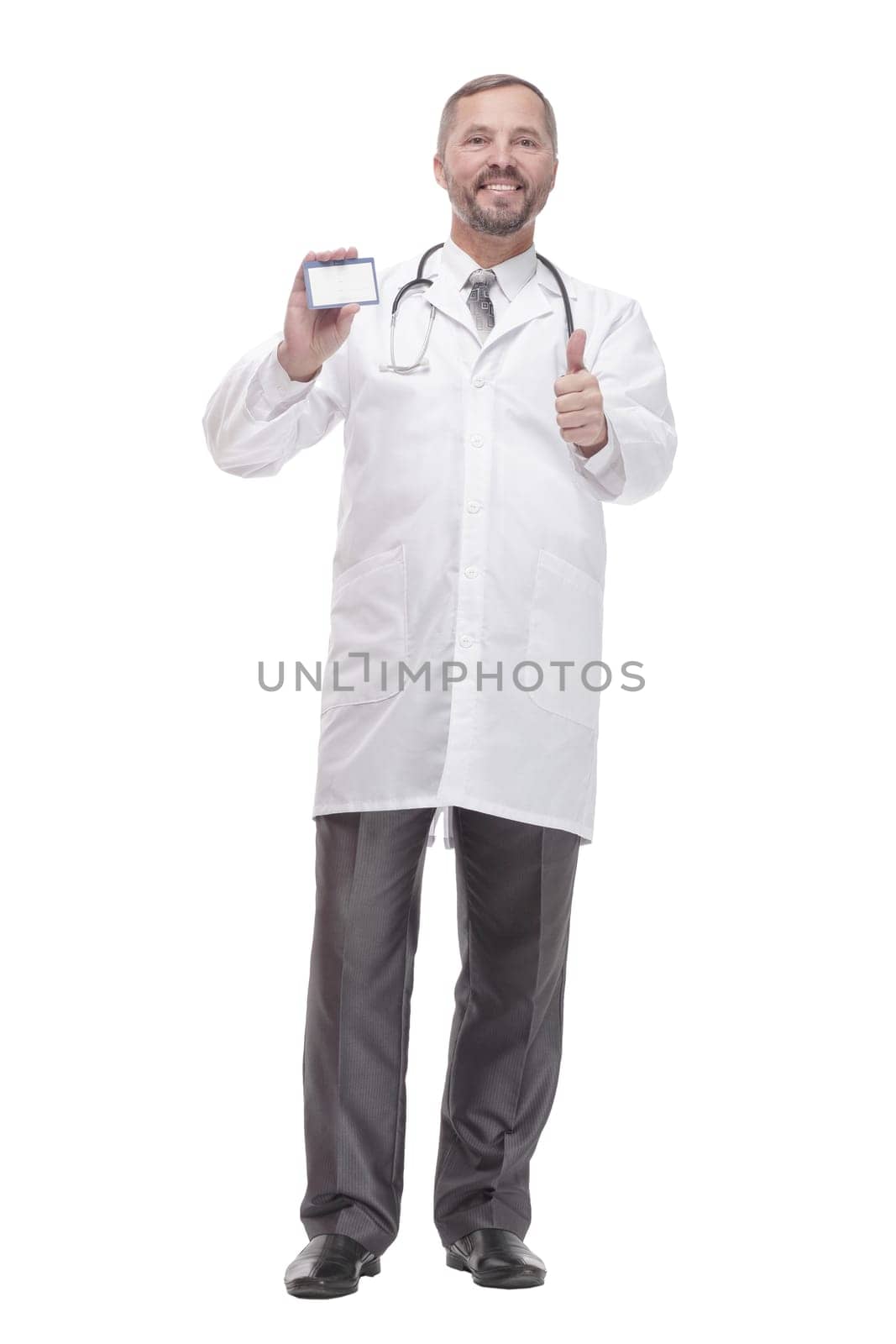 in full growth. smiling doctor showing his visiting card . isolated on a white background.