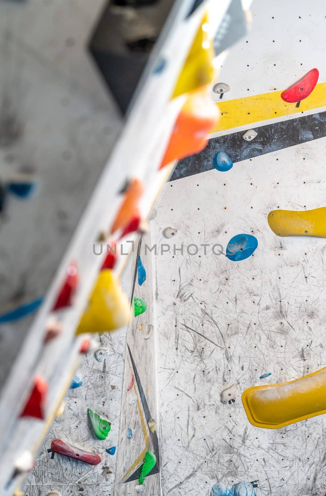 artificial climbing wall with grips and carabiners in the interior. High quality photo