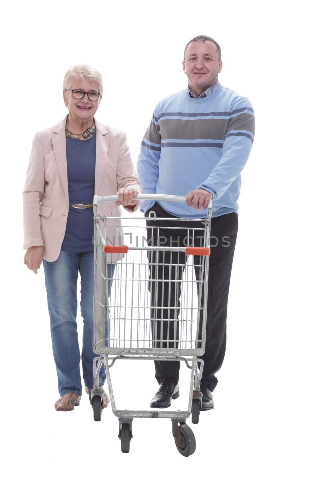 in full growth. happy married couple with shopping cart. isolated on a white background