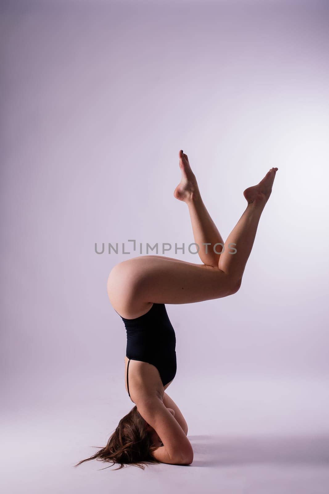 Athletic woman in swimsuit, doing yoga, push-ups, beautiful female exercising at a studio