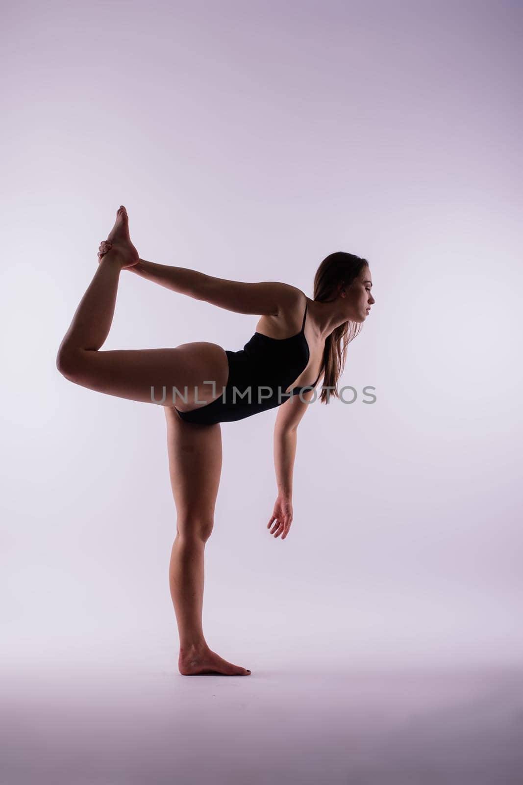 Athletic woman in swimsuit, doing yoga, push-ups, beautiful female exercising at a studio