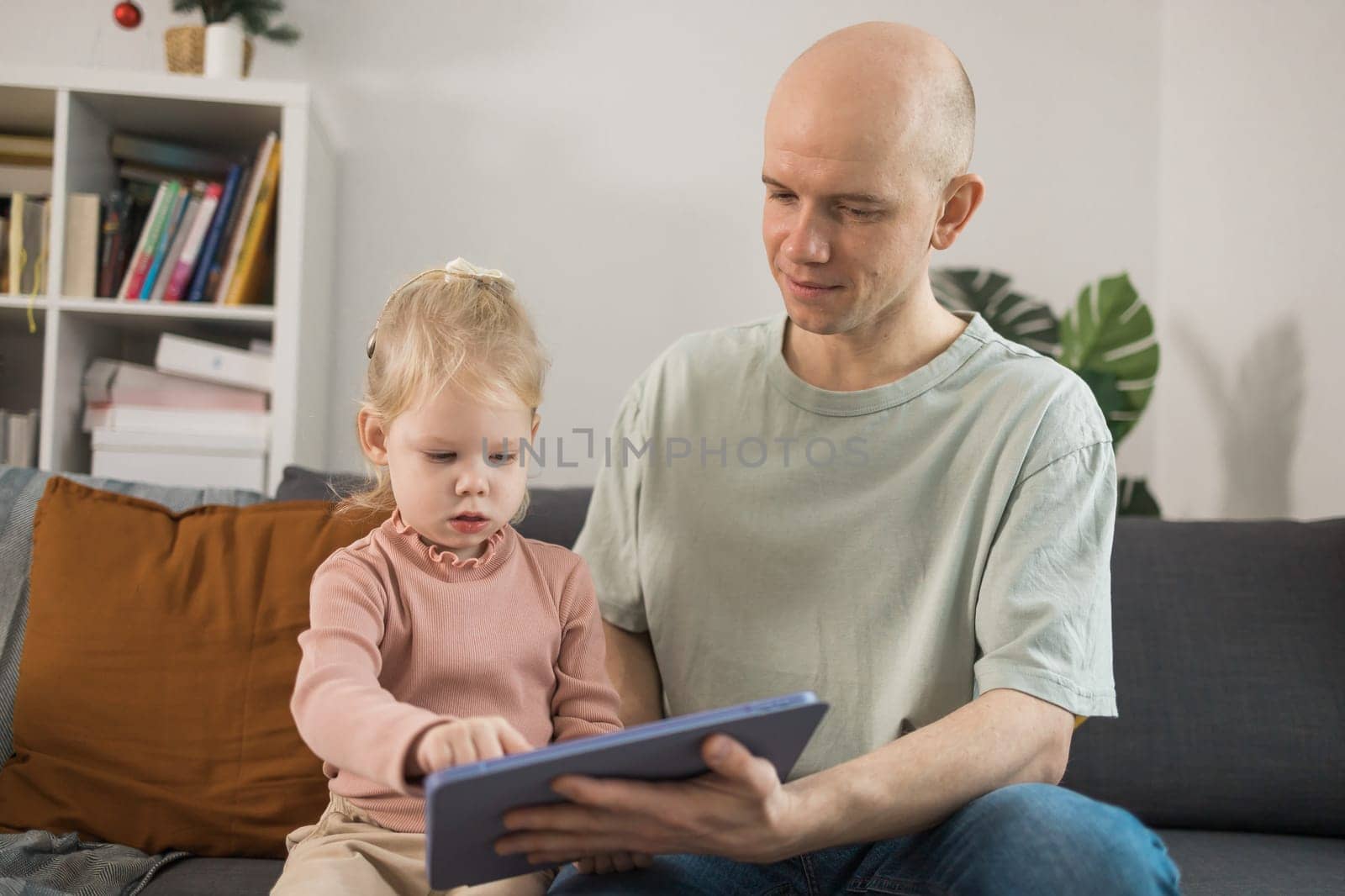 Deaf child girl with cochlear implant studying to hear sounds and have fun with father - recovery after cochlear Implant surgery and rehabilitation concept by Satura86