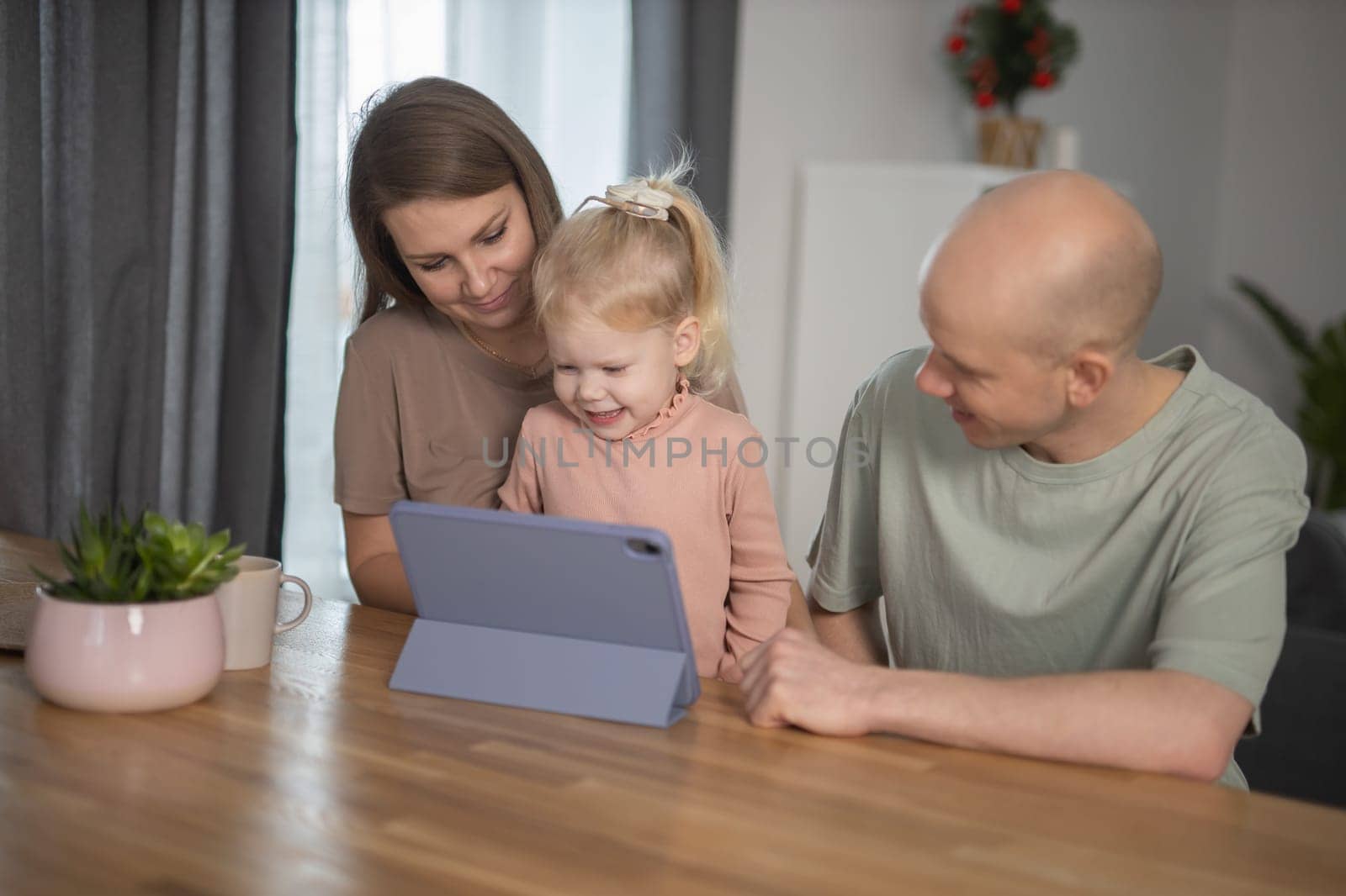 Deaf child girl with cochlear implant studying to hear sounds and have fun with mother and father - recovery after cochlear Implant surgery and rehabilitation concept by Satura86