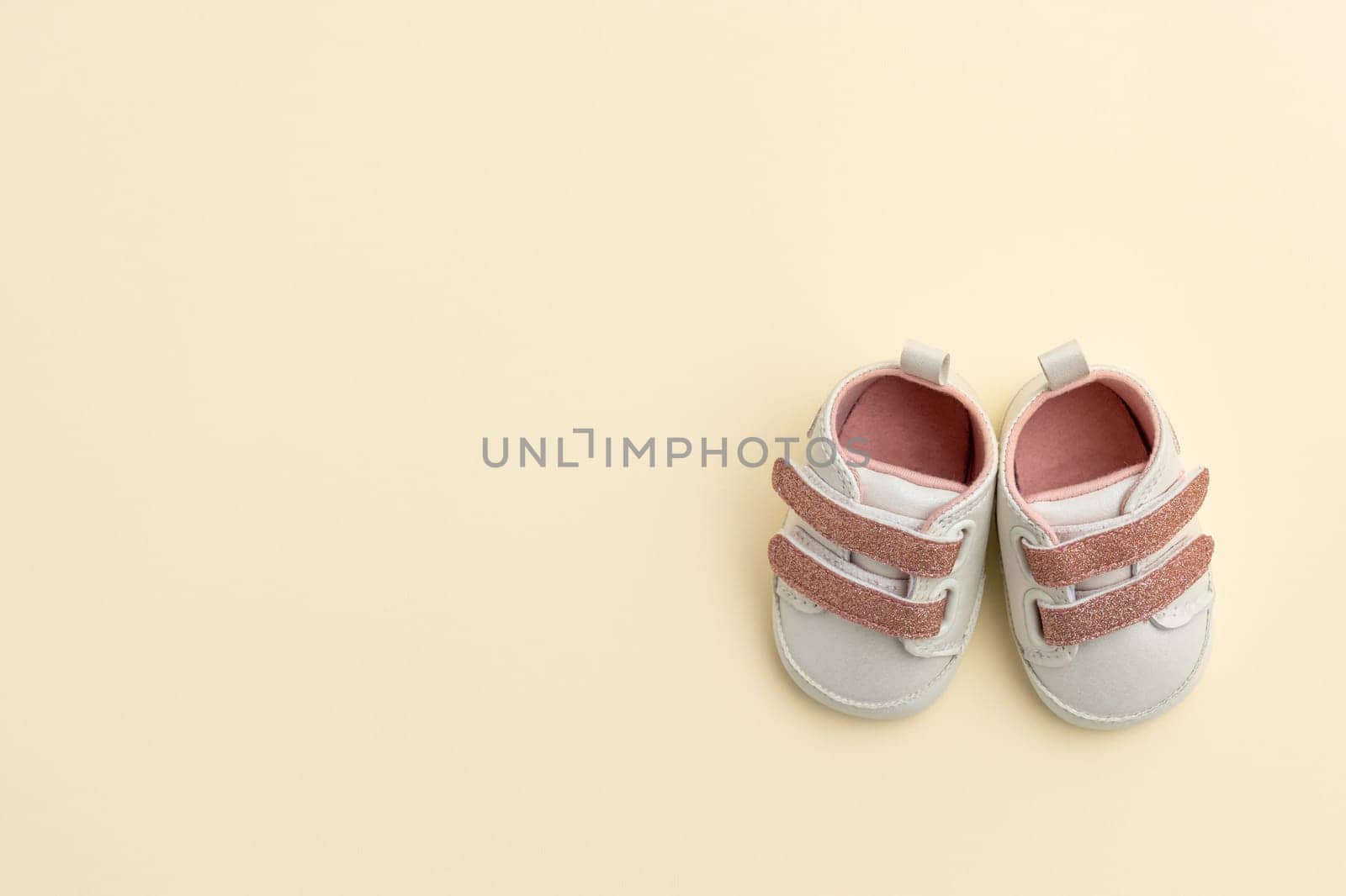 Baby shoes on paper background with copy space. Baby clothes concept. Top view, flat lay by sdf_qwe
