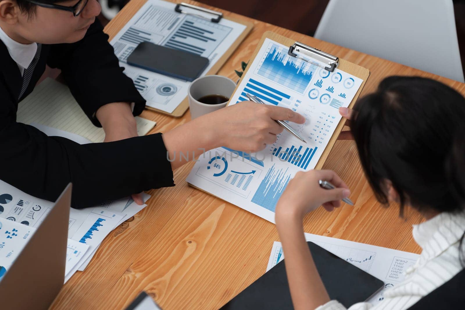 Top-view business team of financial data analysis meeting with business intelligence, report paper and dashboard on laptop for marketing strategy. Business people working together in office of harmony