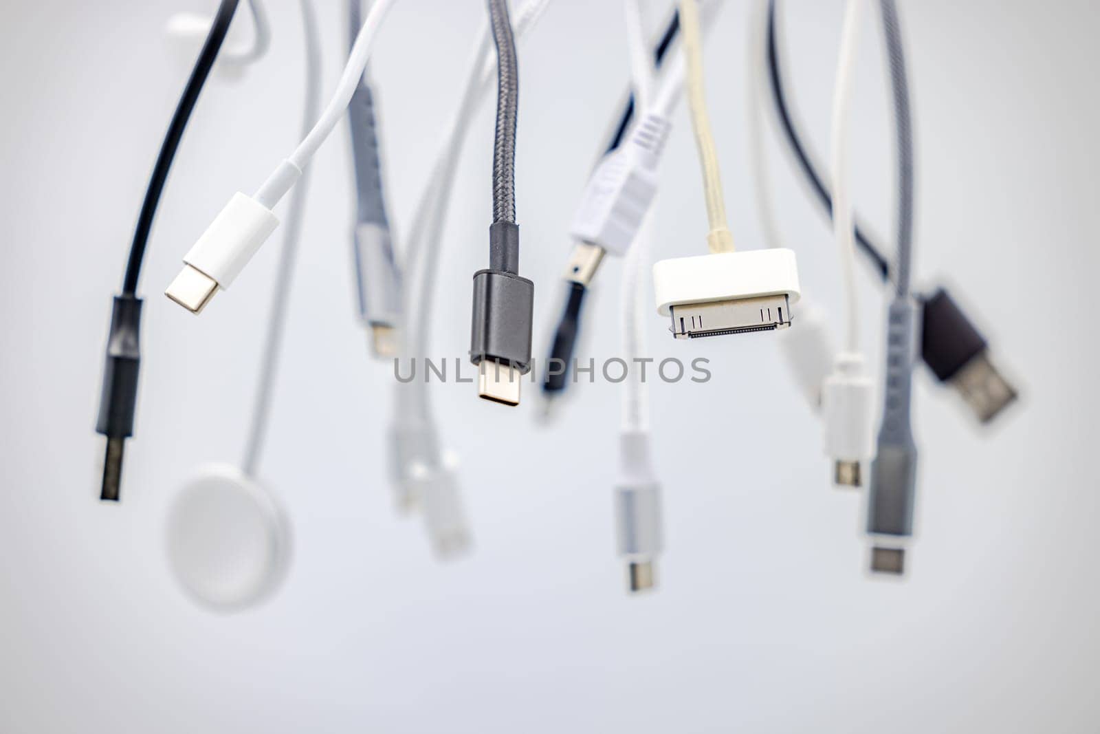 Various USB connectors and cables cropped with selective focus against white background as studio shot