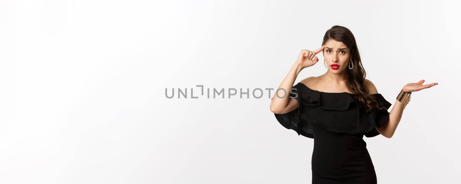 Fashion and beauty. Annoyed and bothered woman pointing at head, scolding someone for stupid mistake, looking confused, standing over white background.
