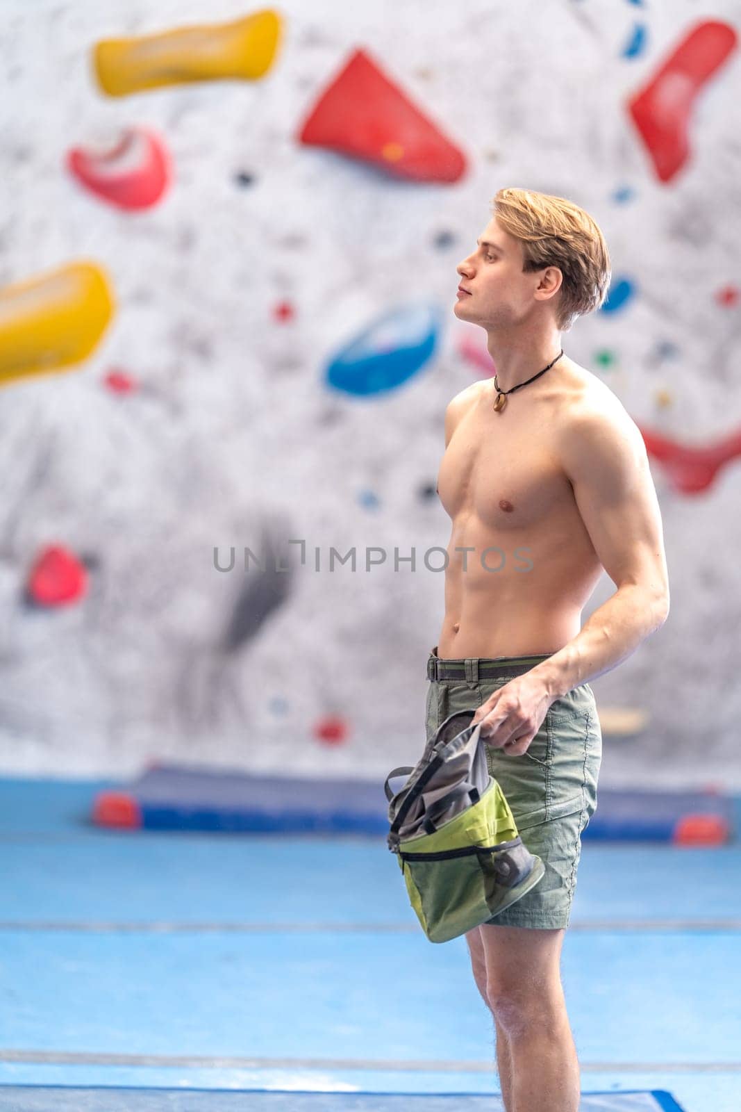 young man on a boulder climbing wall by Edophoto