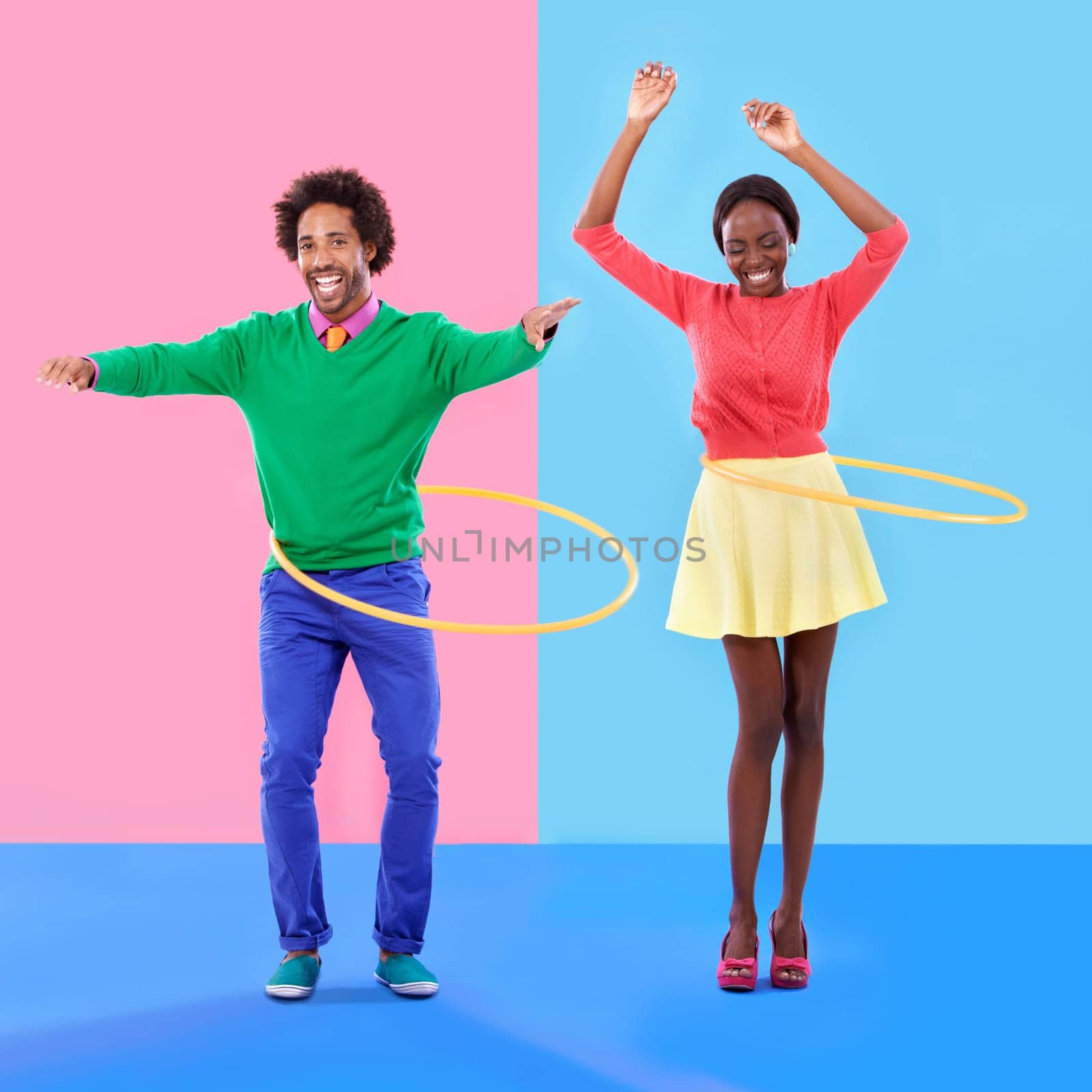 Going for the super spin. Studio shot of a young couple standing against a colourful background. by YuriArcurs