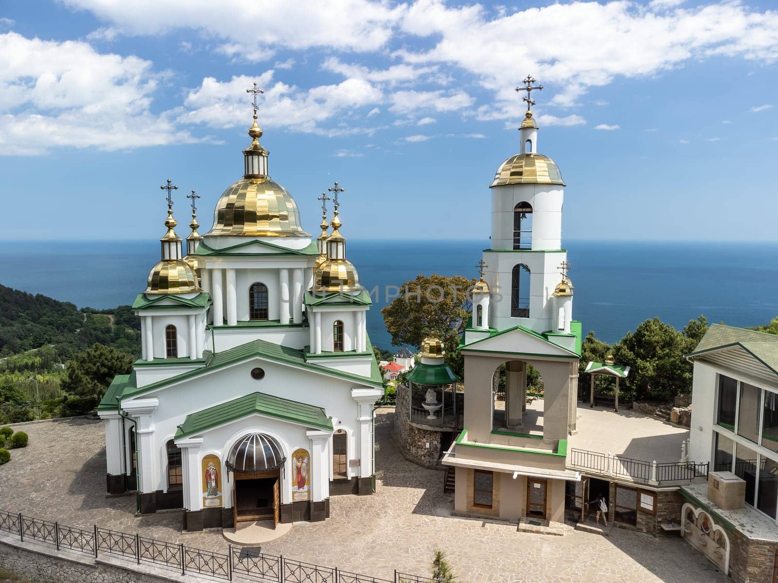 Christian church on a background of mountains. Temple of the Holy Archangel Michael in Oreanda. The southern coast of Crimea. Located on a rocky cliff and is surrounded by beautiful vegetation