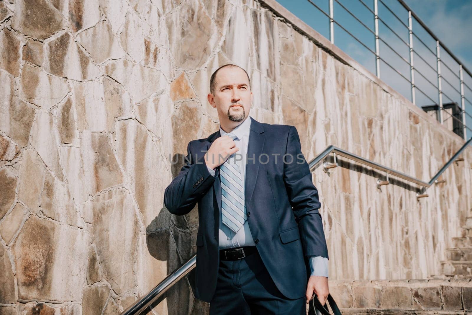 Business executive with briefcase going down the stairs.