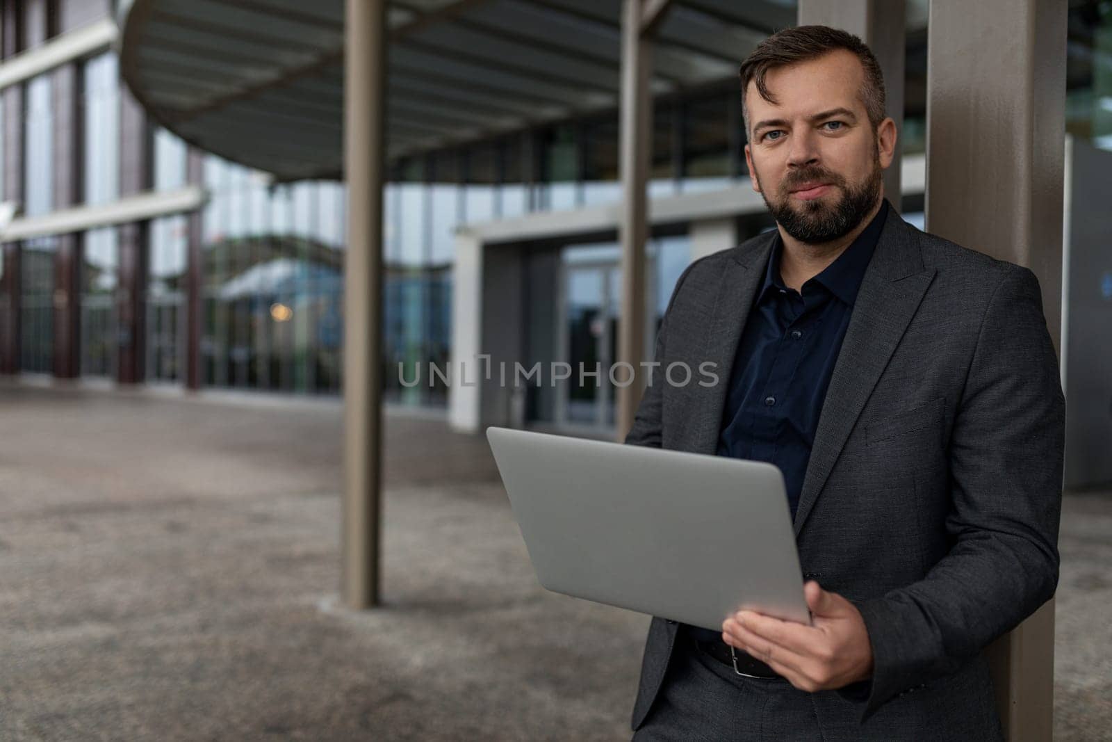 portrait of confident european male designer with laptop in office building campus by TRMK