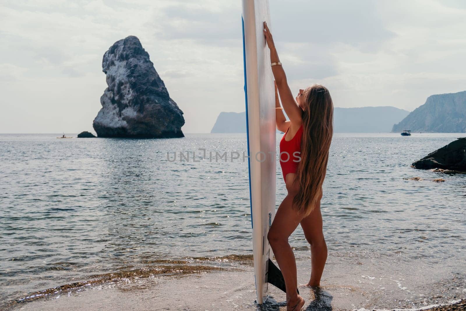 Woman sea sup. Close up portrait of happy young caucasian woman with long hair looking at camera and smiling. Cute woman portrait in bikini posing on sup board in the sea by panophotograph