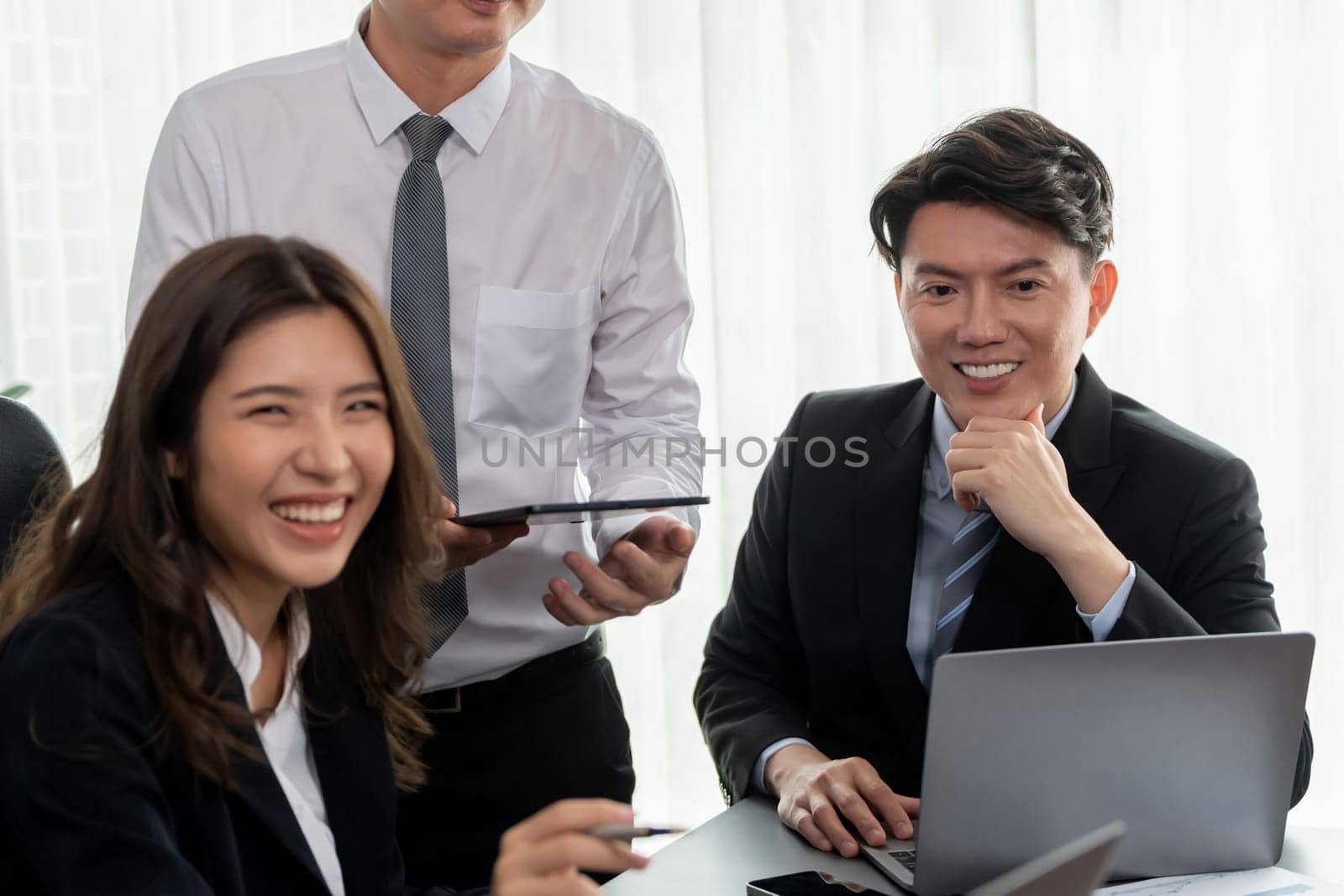 Harmony in office concept as business people analyzing dashboard paper together in workplace. Young colleagues give ideas at manager desk for discussion or strategy planning about project.