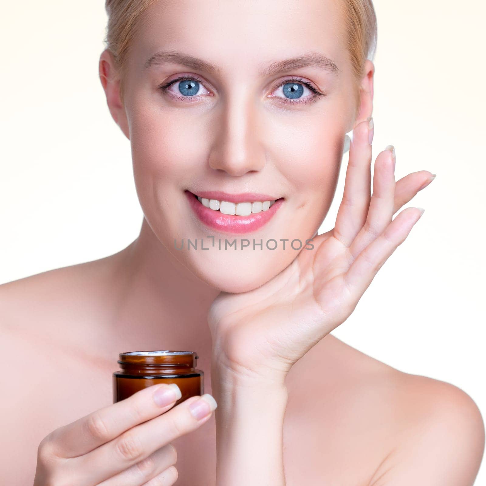 Closeup personable beautiful perfect clean skin soft makeup woman finger applying moisturizer cream on her face for anti aging wrinkle. Facial rejuvenation with expressive hand gesture putting cream.