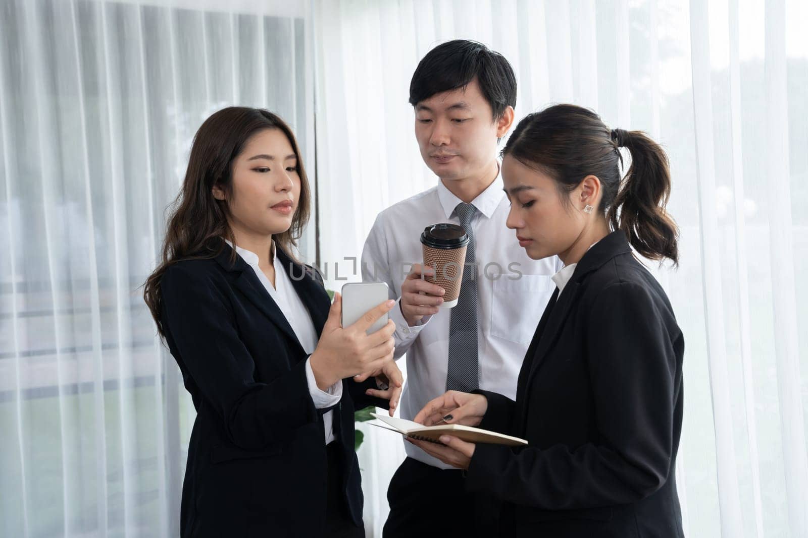 Mentor, manager with coffee advice younger colleagues in workplace. Businesspeople discussing or planning financial project strategy, talking together for harmony and strong teamwork in office concept