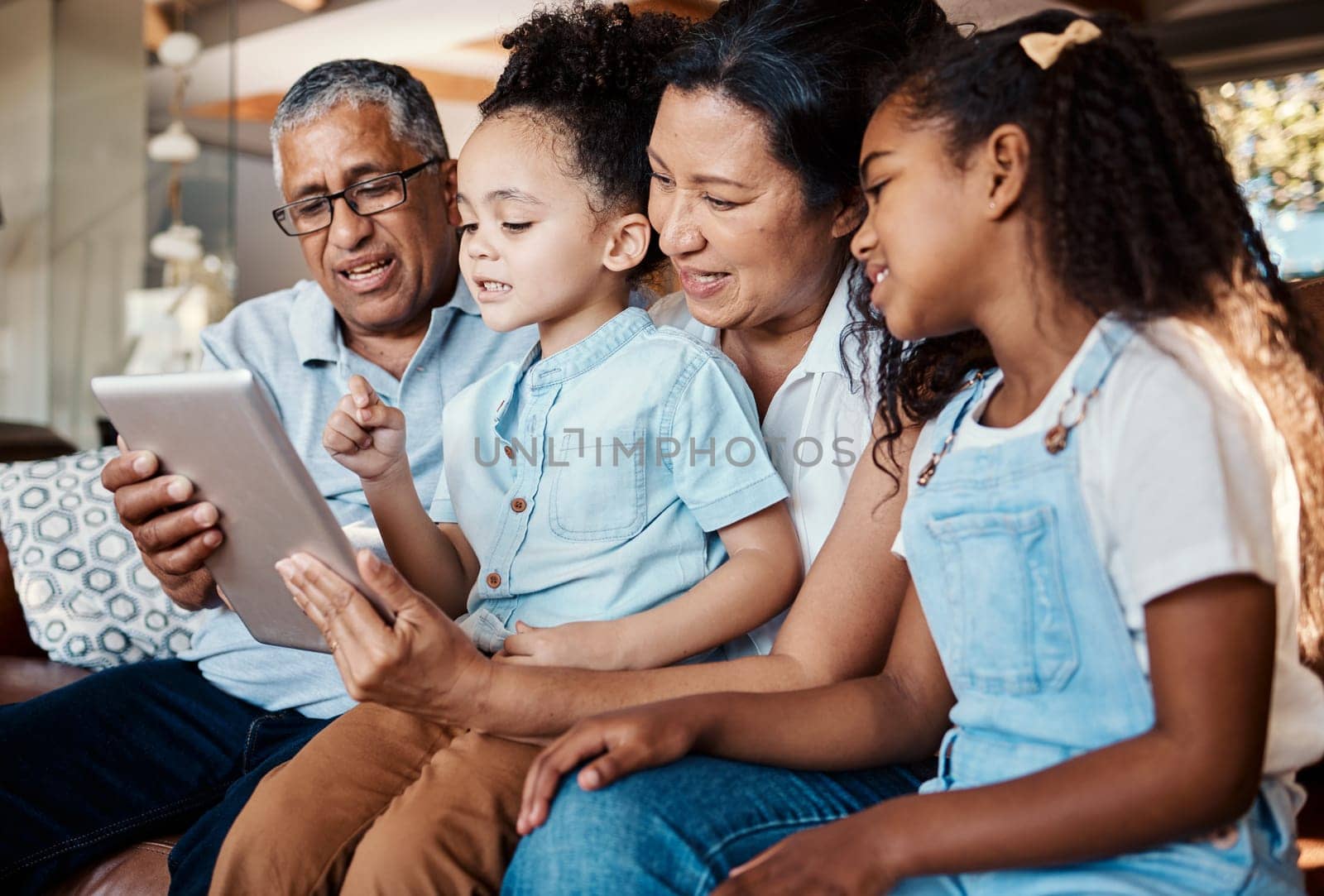 Relax, family tablet and grandparents with girls on sofa in home living room for social media or video streaming. Technology, care and happy grandfather, grandma and kids bonding with touchscreen