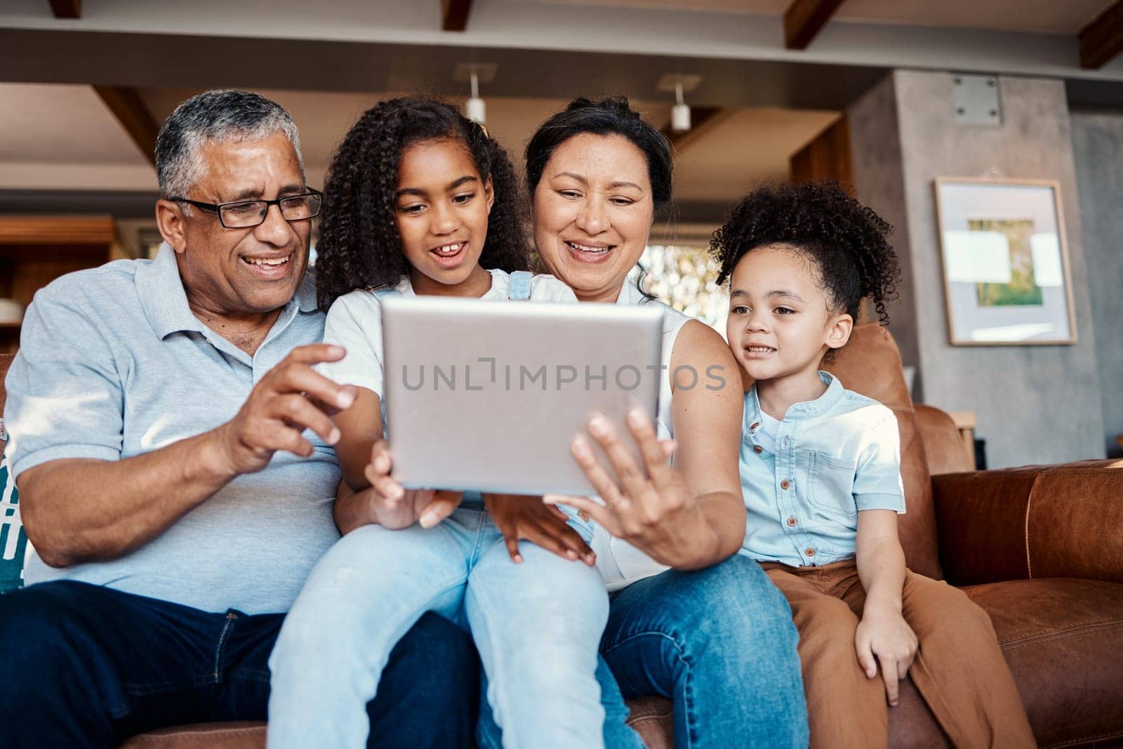 Relax, family and girls with tablet on sofa in home living room for social media or funny video streaming. Technology, care or happy grandfather, grandma and kids laughing or bonding with touchscreen by YuriArcurs