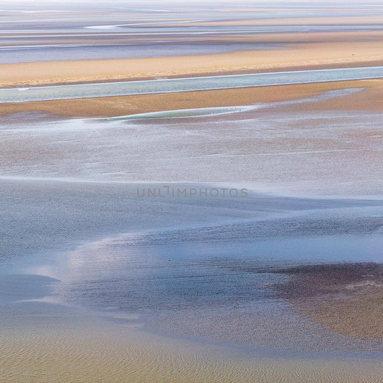 flowing sea water on sand at low tide in the bay of Mont Saint-Michel, abstract composition