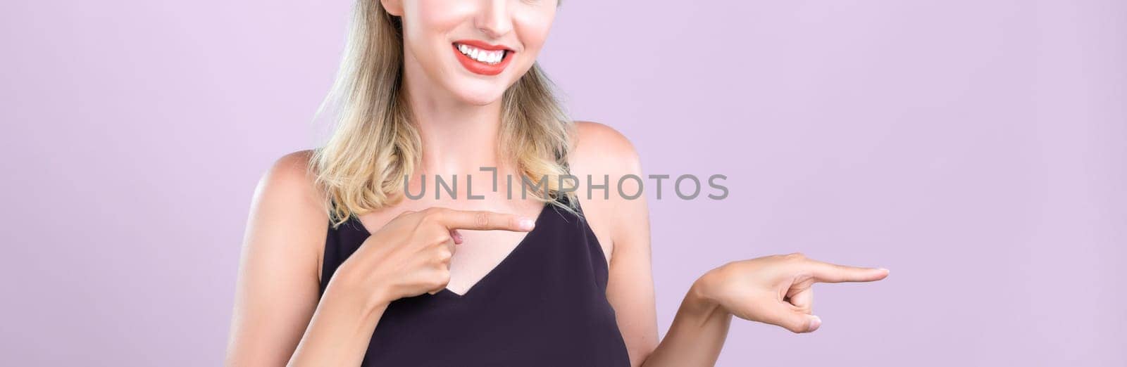Closeup Alluring beautiful perfect makeup clean skin woman portrait pointing finger side way in copyspace isolated background. Promotion indicated by hand gesture concept for skincare advertisement.