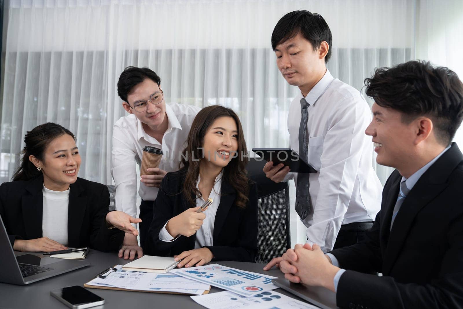 Harmony in office concept as business people analyzing dashboard paper together in workplace. Young colleagues give ideas at manager desk for discussion or strategy planning about project.