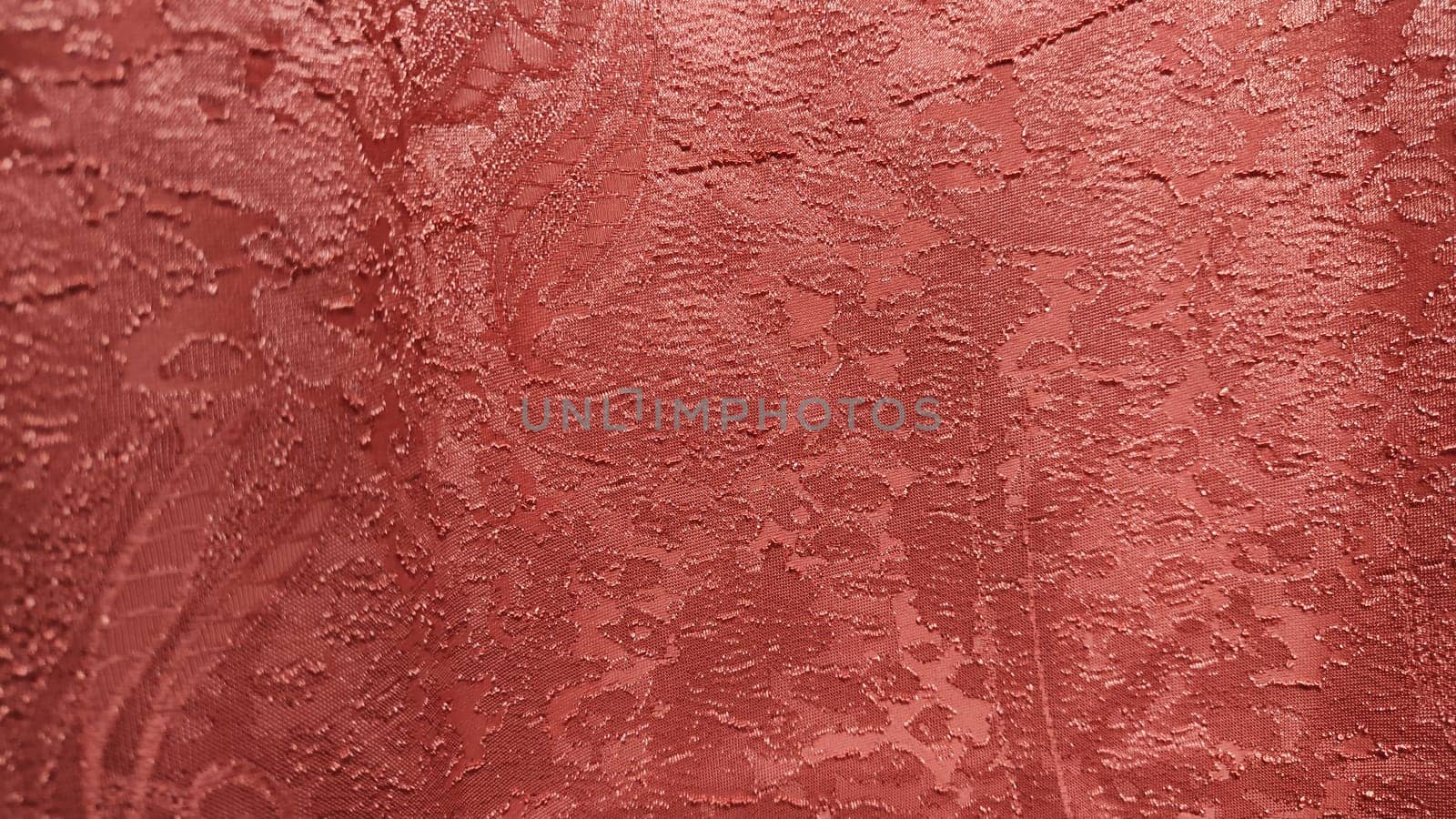 Red fabric with abstract texture for background, close-up. Small pattern on curtain