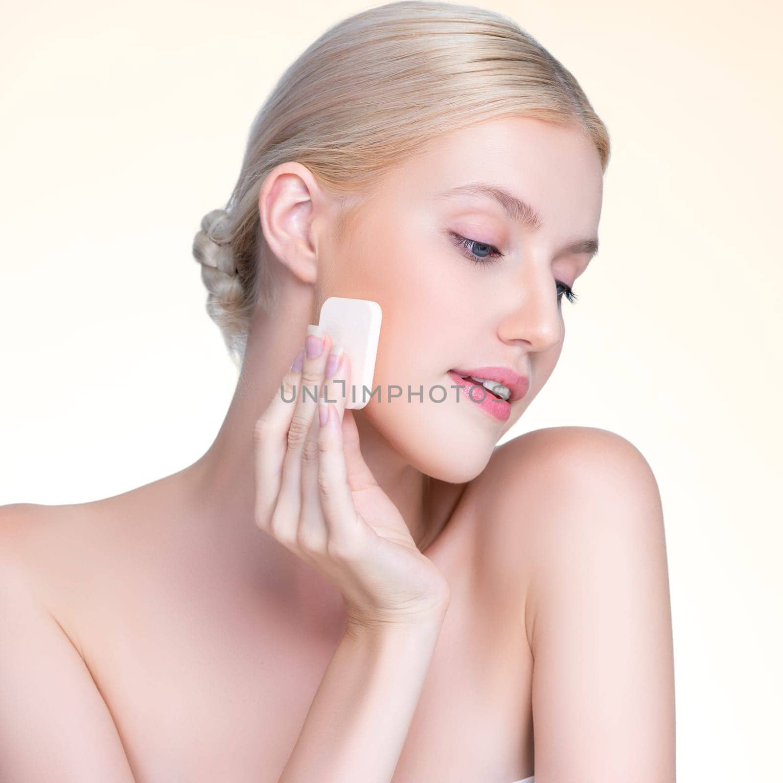 Closeup personable beautiful natural soft makeup woman using powder puff for facial makeup concept. Cushion foundation applying on young girl face in isolated background.