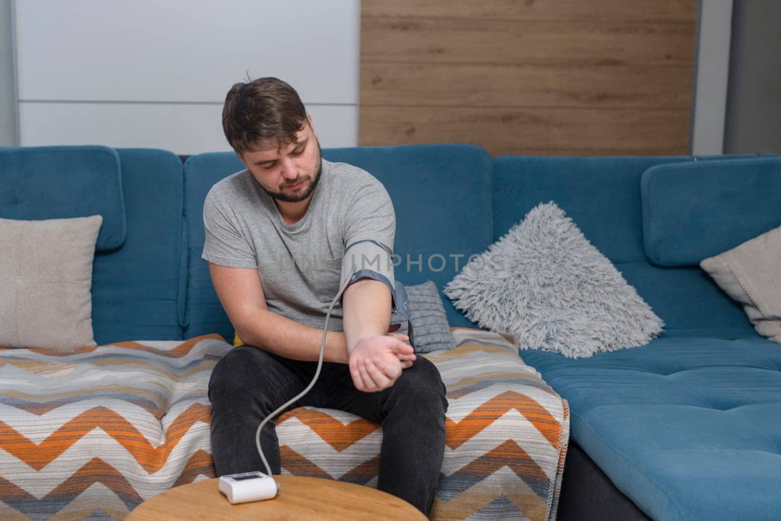 Man measuring his blood pressure holding his head and feeling sick.