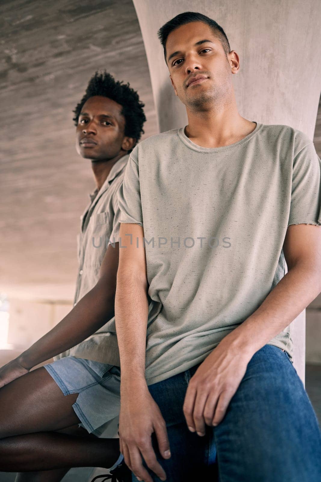 Portrait, fashion and diversity with friends in an urban city together for grunge style on a concrete background. Confident, streetwear and gen z with cool young men sitting in a town to relax.