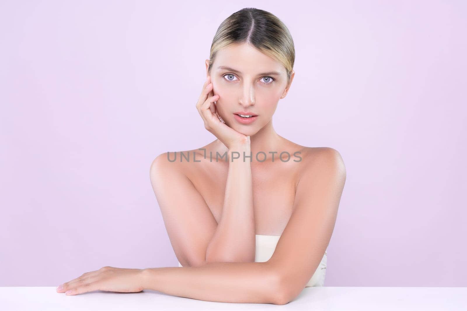 Alluring beautiful woman with perfect smooth and clean skin portrait in isolated background. Beauty hand gesture with expressive facial expression for skincare treatment product or spa.