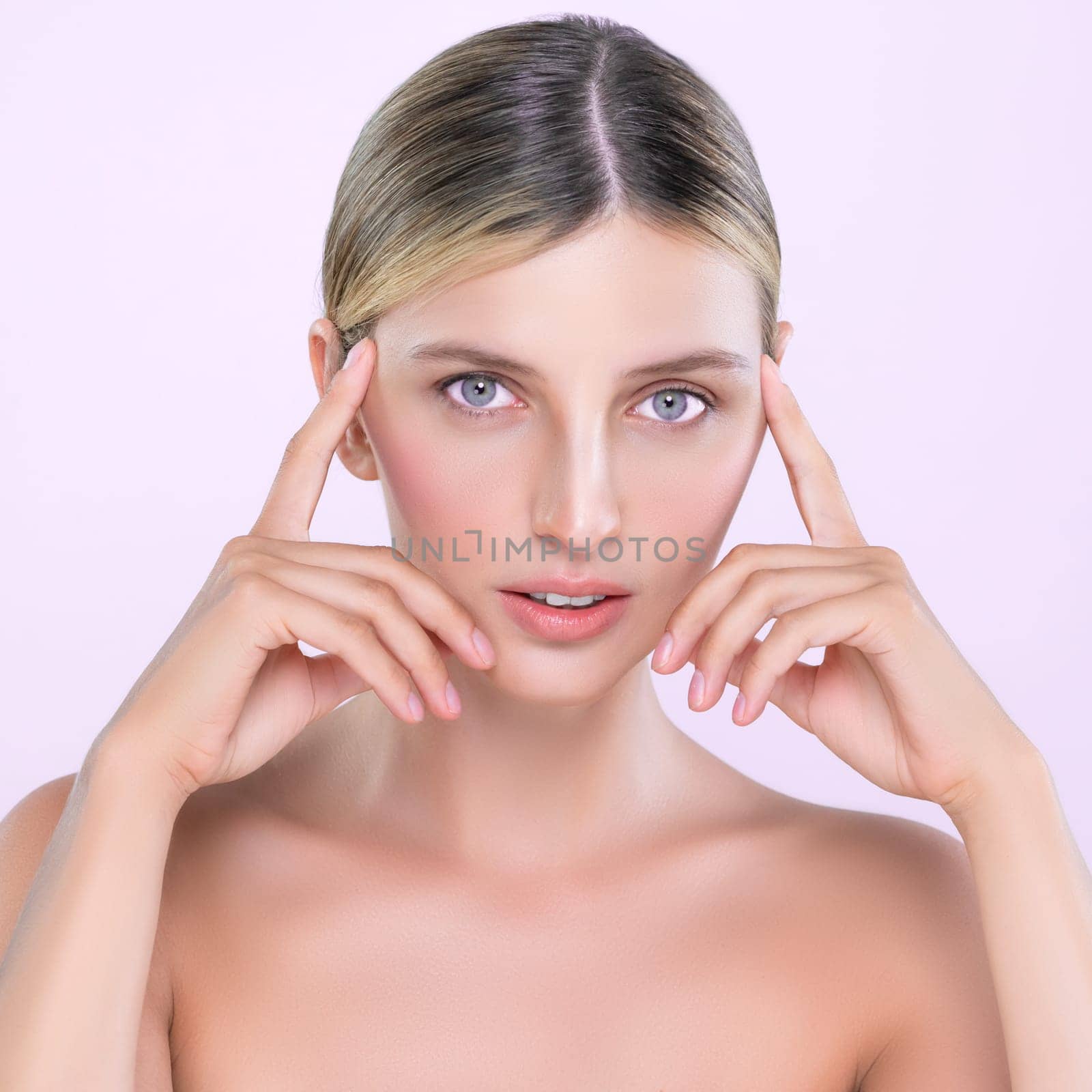 Alluring beautiful woman with perfect smooth and clean skin portrait in isolated background. Beauty hand gesture with expressive facial expression for skincare treatment product or spa.