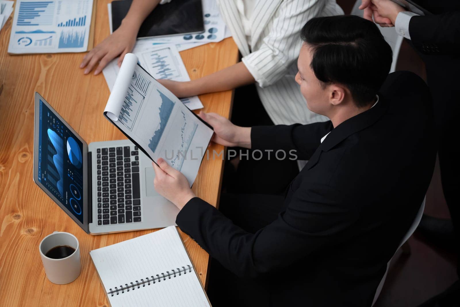 Top-view business team of financial data analysis meeting with business intelligence, report paper and dashboard on laptop for marketing strategy. Business people working together in office of harmony