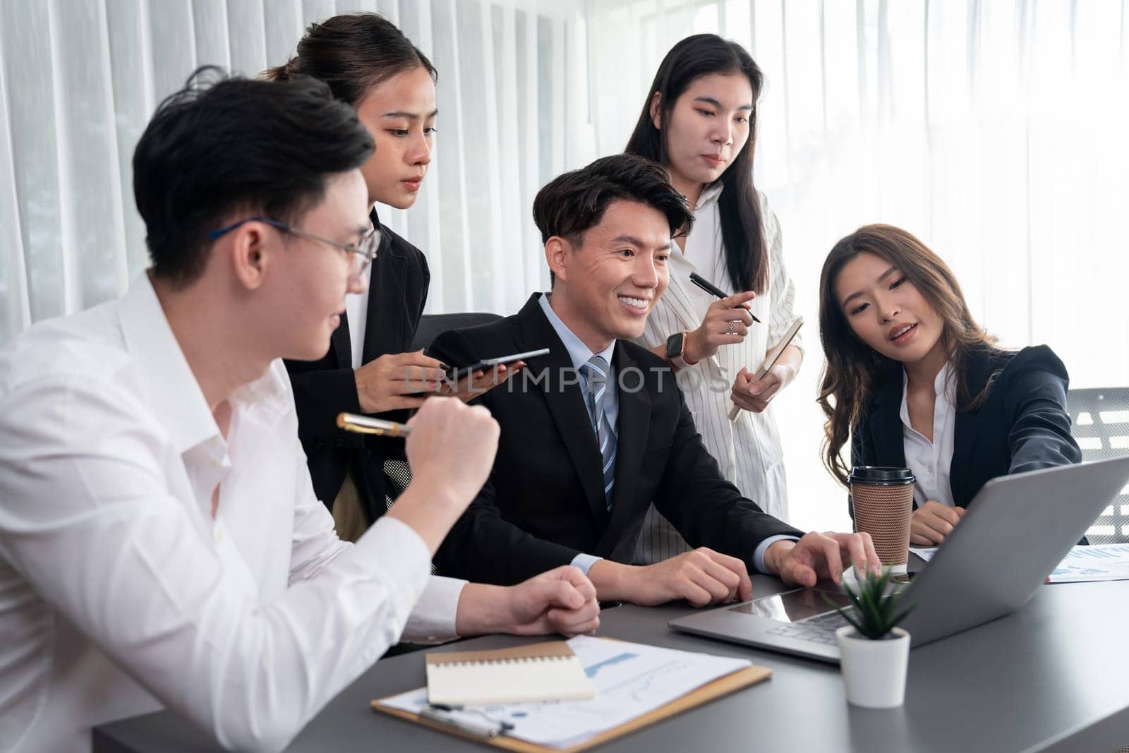 Harmony in office concept as business people analyzing dashboard paper together in workplace. Young colleagues give ideas at manager desk for discussion or strategy planning about project.