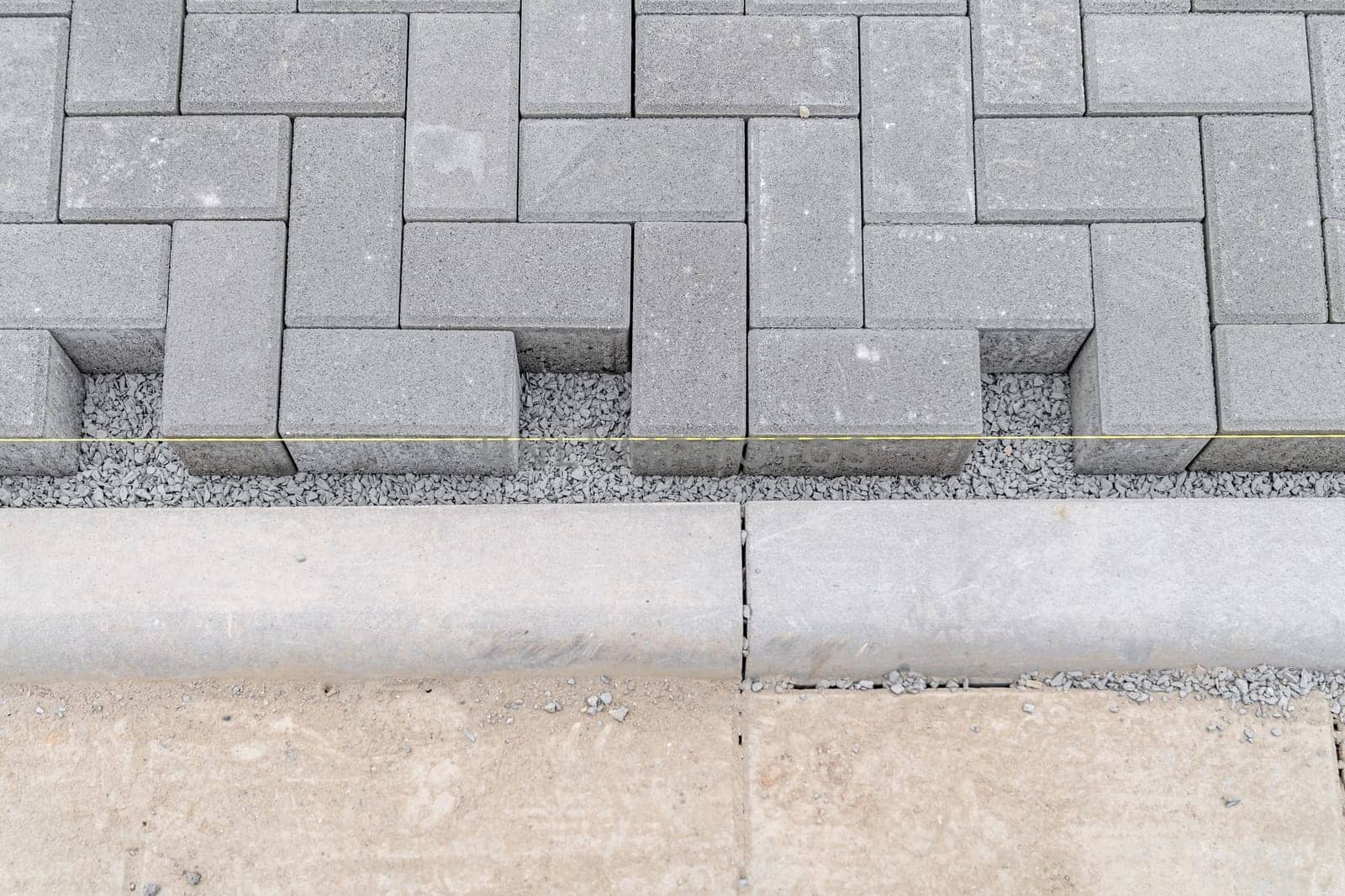 building a sidewalk, laying interlocking pavers.