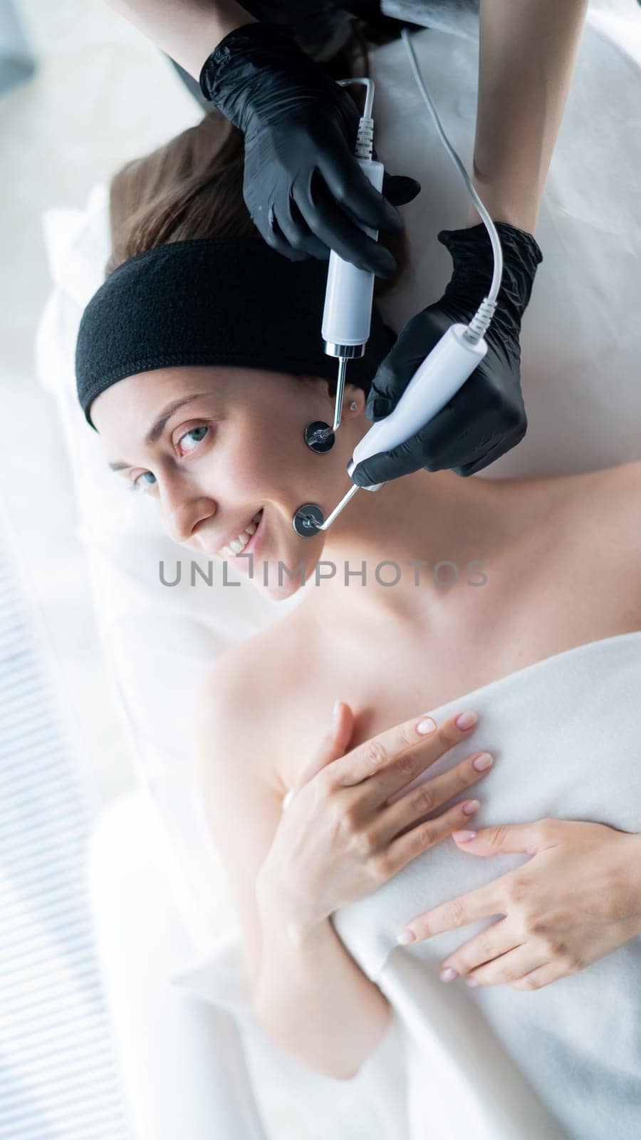Young caucasian woman on microcurrent therapy procedure. Beautician's office