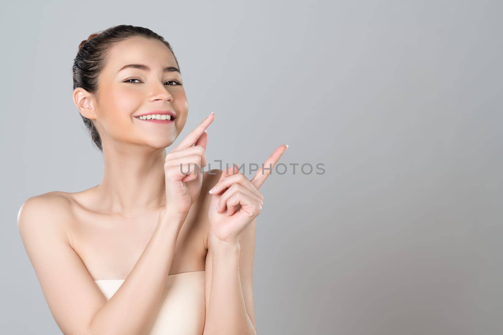 Glamorous woman pointing finger advertising product in isolated background. by biancoblue