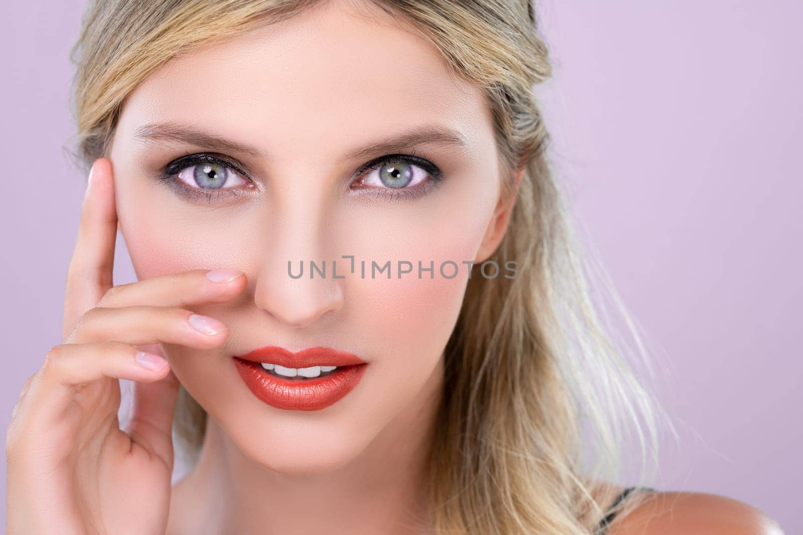Closeup pretty beautiful woman with alluring perfect smooth and clean skin portrait in pink isolated background. Hand gesture with expressive facial expression for beauty model concept.
