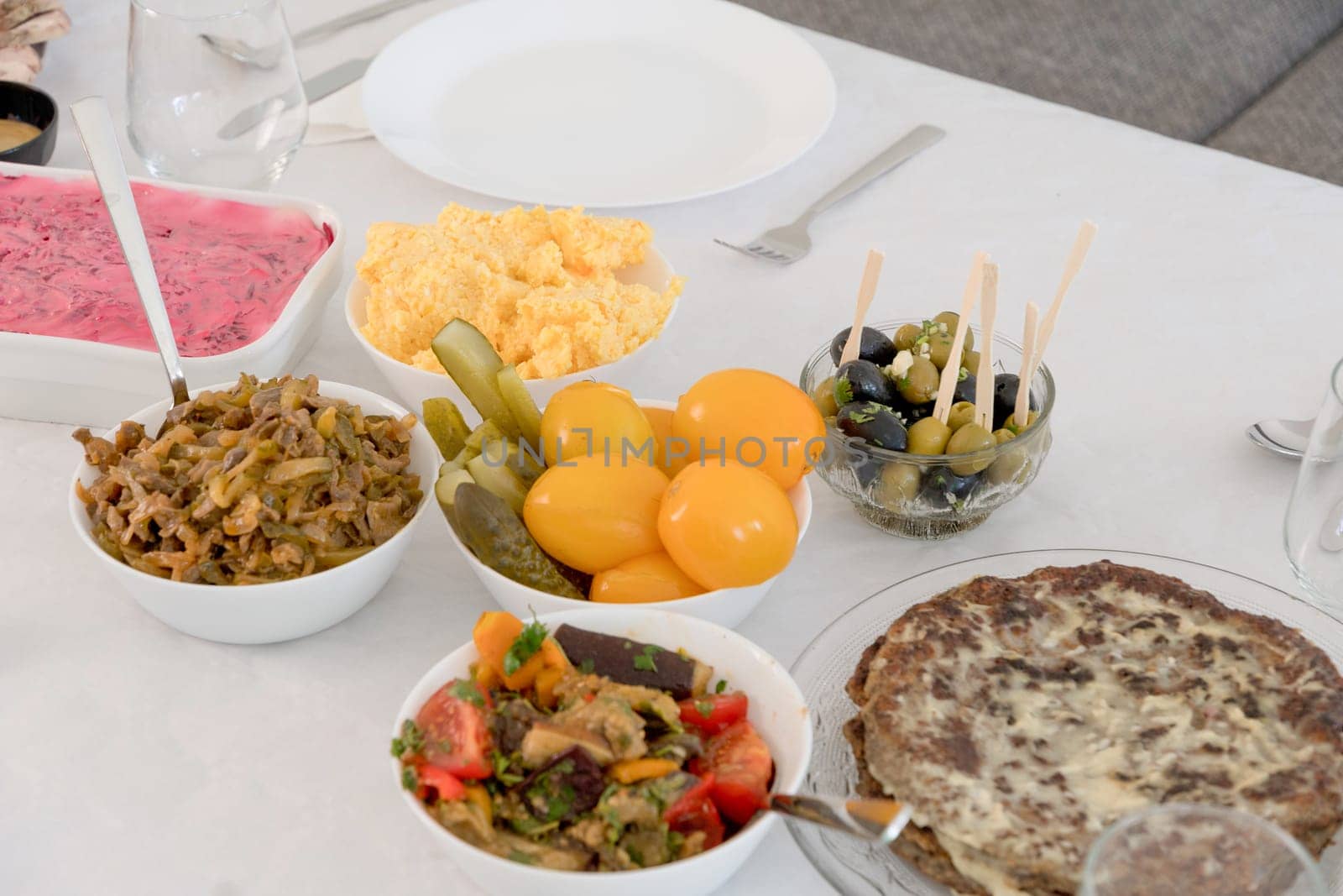 festive snacks on the table pickled tomatoes mushrooms liver cake herring under a fur coat traditional table for the New Year in Russia. High quality photo