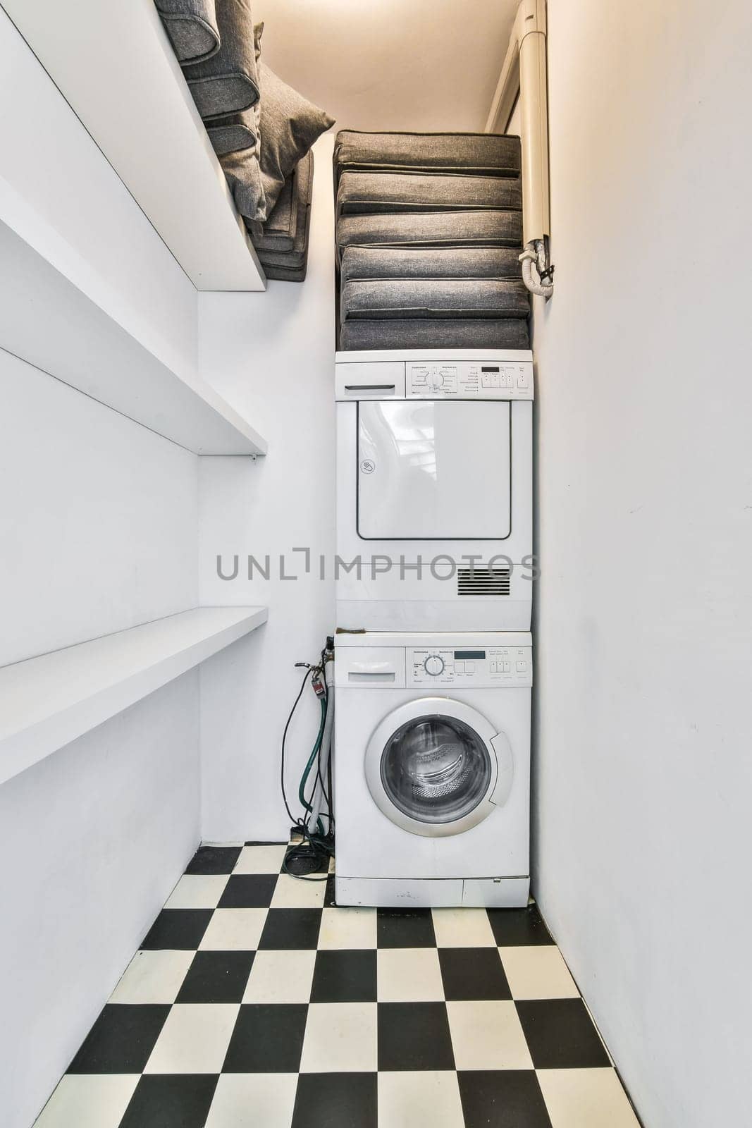 a laundry room with a washer and dryer on the floor in black and white checkereded tiles