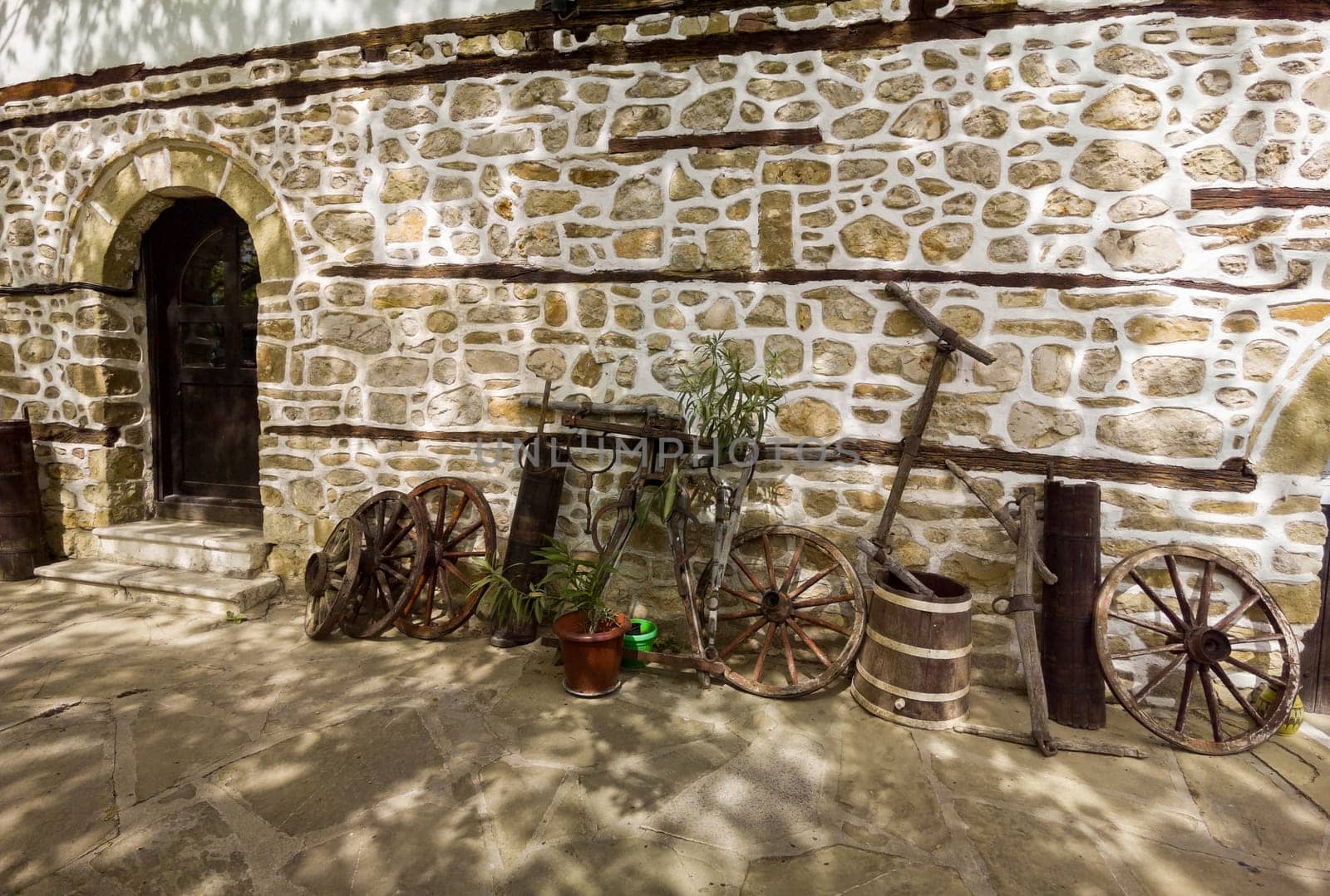 old stone house with vintage things and wooden wheels