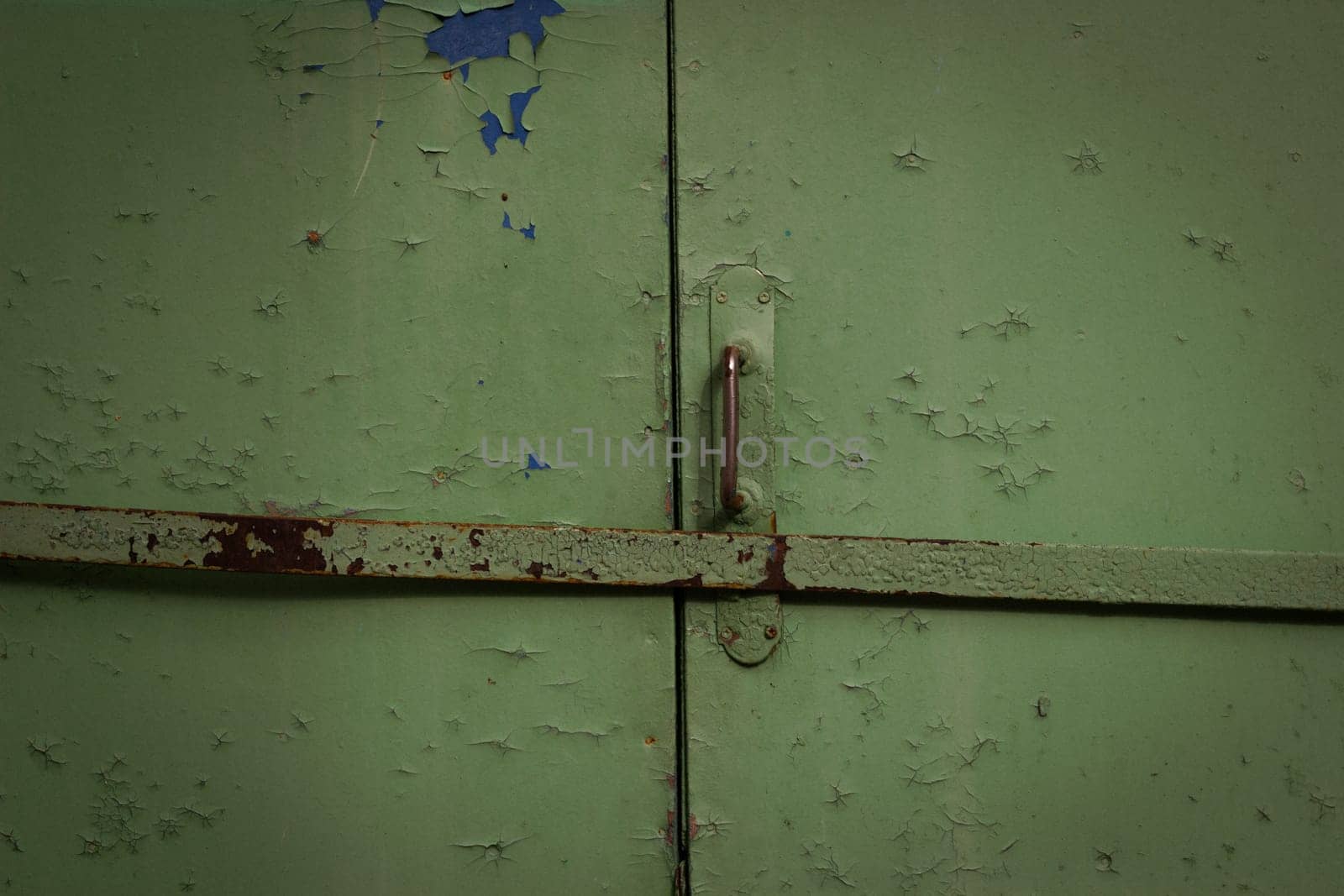 Abstract background old metal green garage doors are closed with an iron bolt. Protection of property and penetration of thieves.