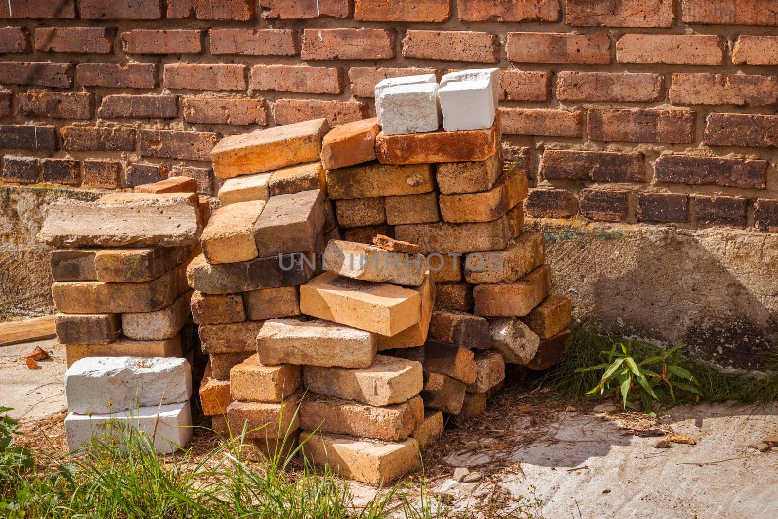 Photo a pile of bricks on the background of an old wall. Construction and repair.