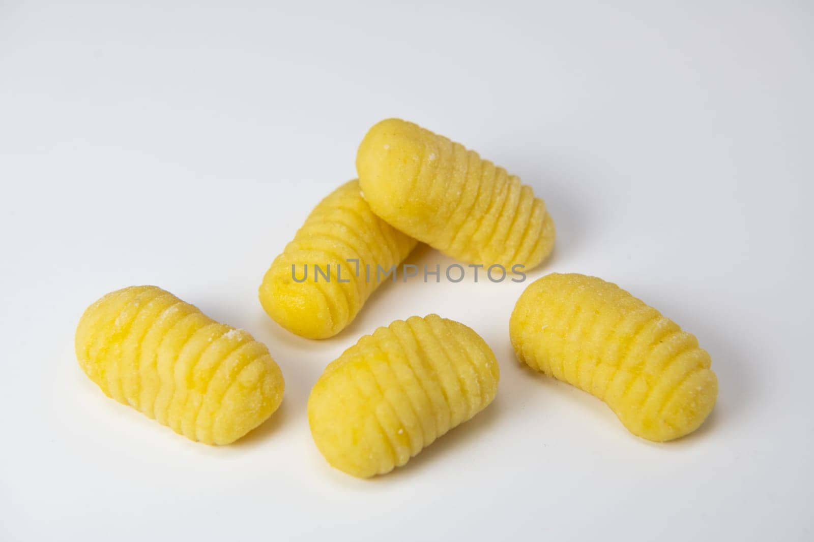 Pile of yellow eggs gnocchi dough dumplings isolated over the white background, High quality photo