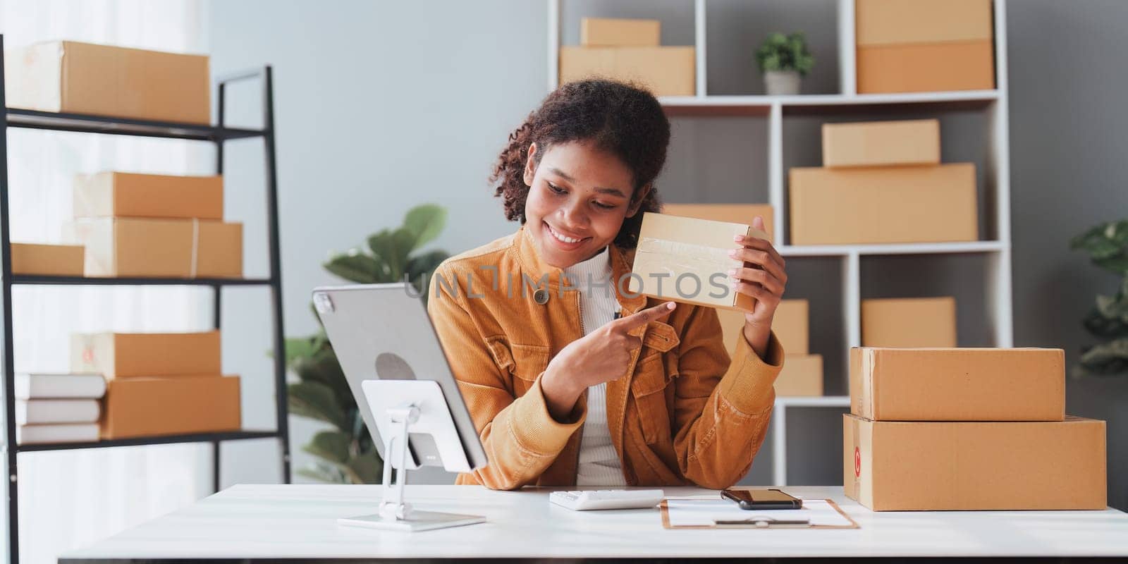 American African entrepreneur smile and use a tablet to live stream. Successful SME entrepreneur concept.