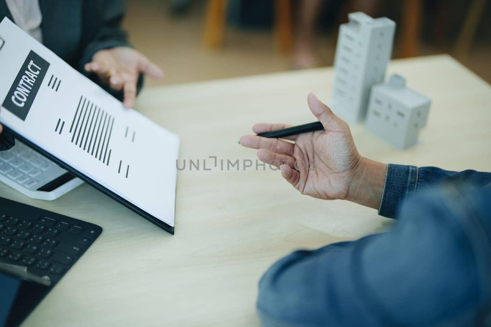 Guarantee Insurance Sign a contract, couple a smiling couple is signing a contract to invest in real estate with the Mortgage officer with the bank.