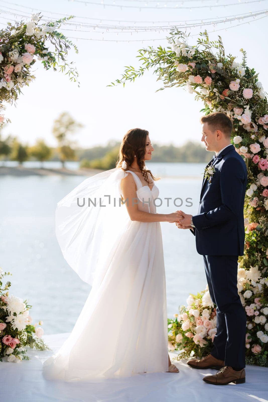 wedding ceremony on a high pier near the river with invited guests