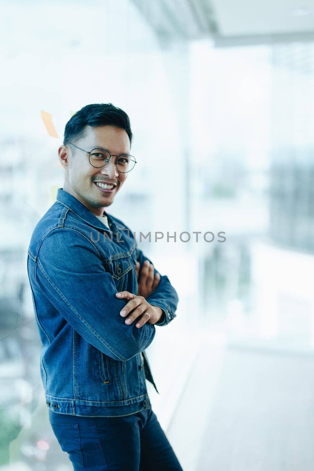 Asian male business owner smiling in front, showing his success in business investment.