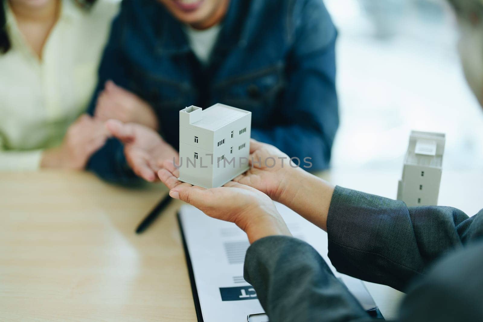 Guarantee Insurance Sign a contract, couple a smiling couple is signing a contract to invest in real estate with the Mortgage officer with the bank by Manastrong