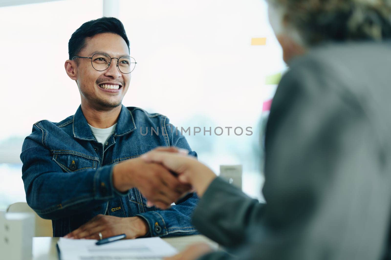 The bank's Mortgage Officers shake hands with customers to congratulate them after signing a housing investment loan agreement.